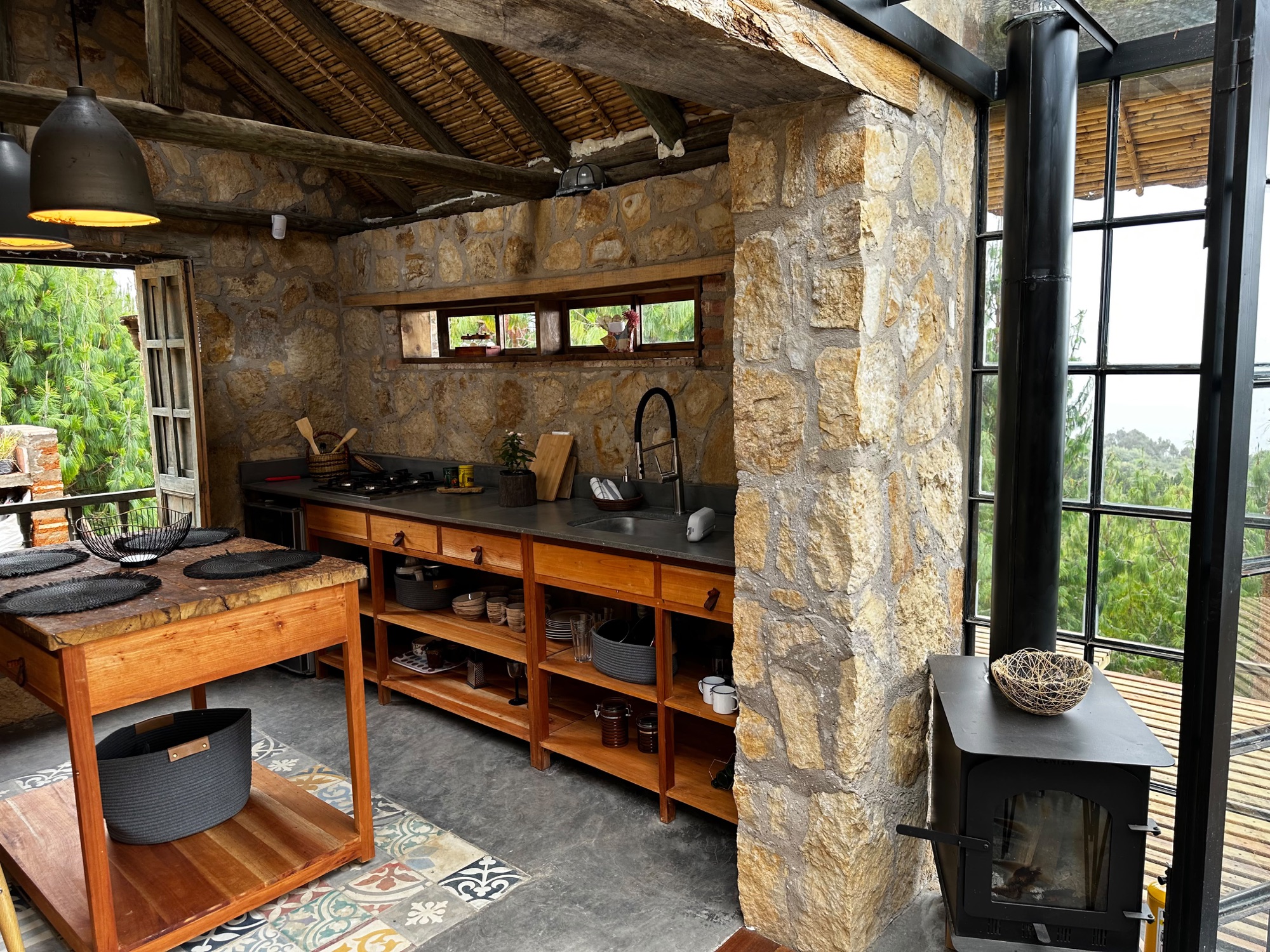 Cocina en muro de piedra con estufa de leña